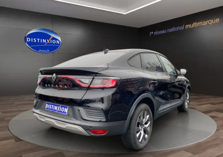 Renault Arkana noir vu en 3/4 arrière droit, avec feux arrière LED et jantes alliage visibles en showroom.