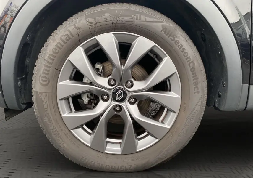 Gros plan sur la roue avant droite du Renault Arkana noir 2024 avec jante alliage et pneu Continental AllSeasonContact.
