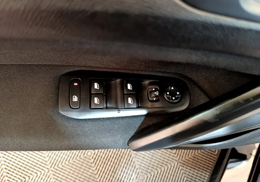 Panneau de commandes des vitres et rétroviseurs côté conducteur d’une Peugeot 308 noire, vue intérieure.