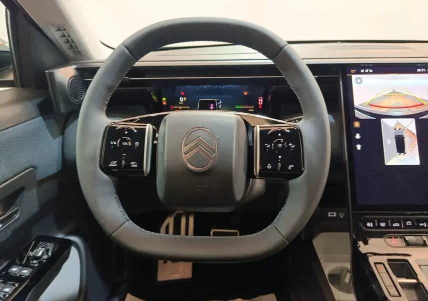 Vue intérieure centrée sur le volant cuir noir de la Citroën C5 Hybride avec écran tactile et affichage multifonctions.