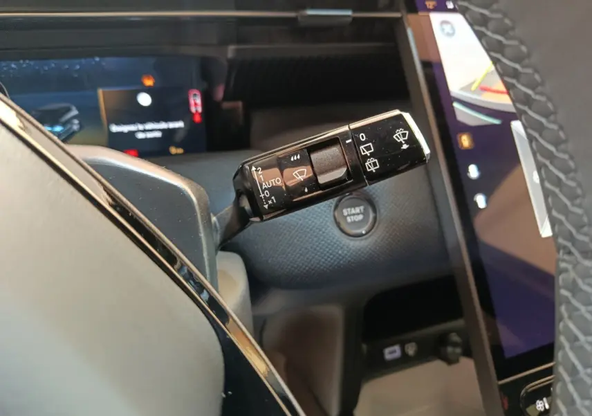 Gros plan sur la commande d’essuie-glace noire dans l’habitacle du Citroën C5 Hybride 2026, avec bouton start/stop visible.