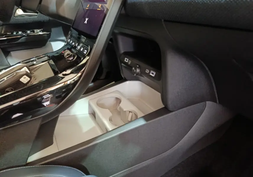 Intérieur noir de la Citroën C5 Hybride 2026, vue console centrale avec écran tactile et porte-gobelets.