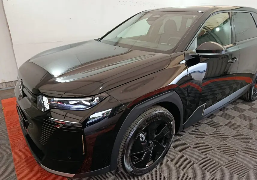 Vue 3/4 avant droite d'une Citroën C5 Hybride noire, soulignant ses phares LED et jantes noires distinctives.