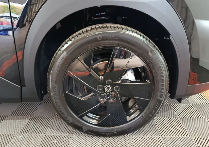 Gros plan sur la roue avant droite noire brillante du Citroën C5 Hybride 2026 avec jante au design moderne.