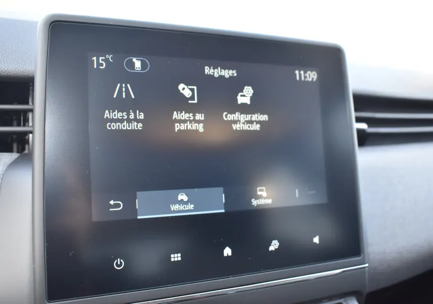 Écran tactile central de la Renault Clio V gris, affichant les réglages d’aides à la conduite et au parking.