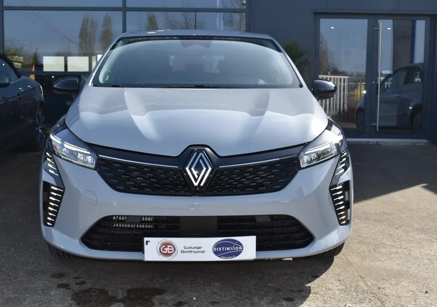 Vue frontale d'une Renault Clio V TCE 90 gris 2024 avec calandre noire et feux LED verticaux distinctifs.