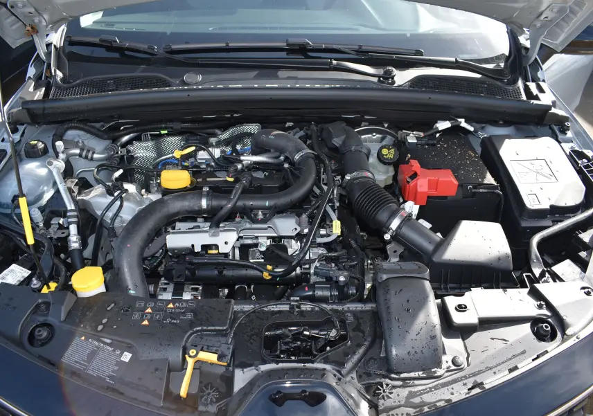 Moteur essence Renault Clio V TCE 90 gris 2024 vu de dessus avec capot ouvert et éléments moteurs visibles.
