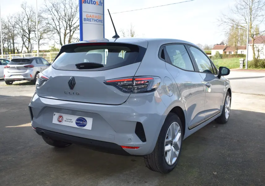 Vue 3/4 arrière droite d'une Renault Clio V gris clair 2024 avec feux arrière LED et jantes alliage.
