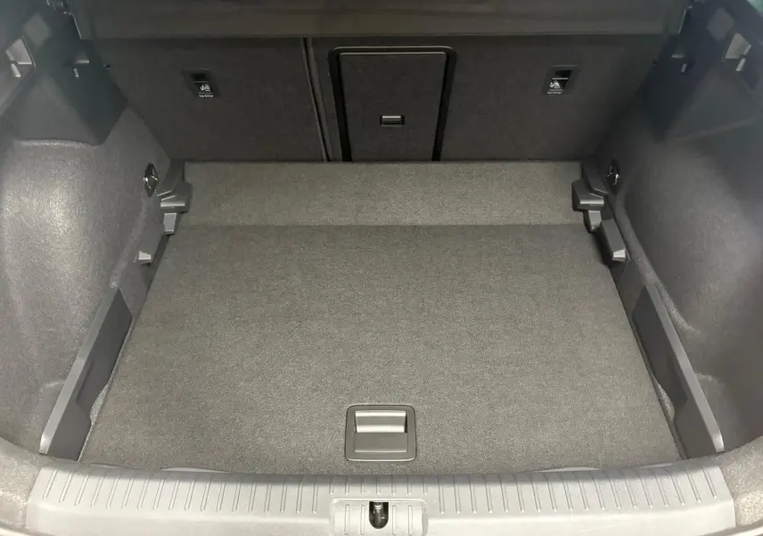 Coffre spacieux et propre du CUPRA Formentor gris Graphène, vue de l'intérieur arrière avec plancher plat et rangements latéraux.