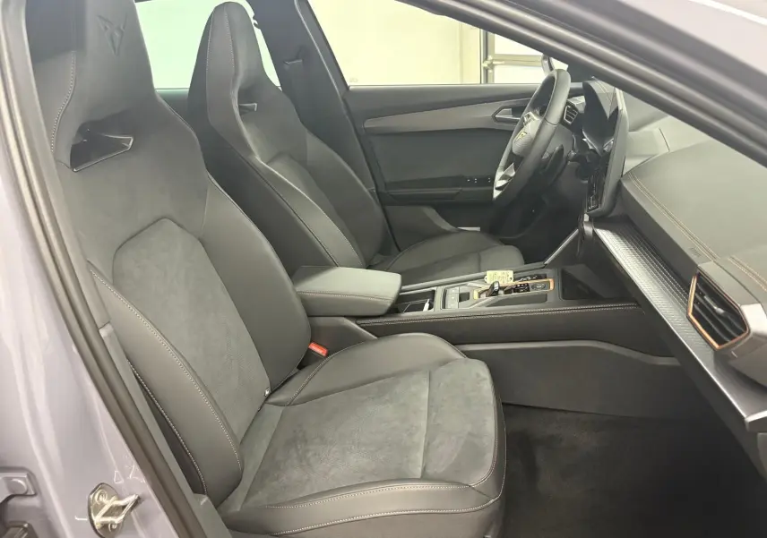 Intérieur côté conducteur du CUPRA Formentor 2025, sièges sport noirs avec surpiqûres contrastées et volant multifonction.