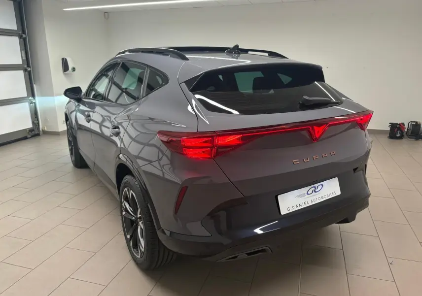 Vue 3/4 arrière droite du CUPRA Formentor gris Graphène 2025 avec toit ouvrant panoramique et jantes alliage 18 pouces.