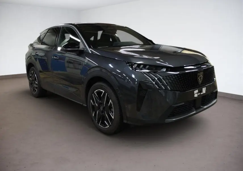 Peugeot 3008 Hybrid 145 GT gris Titane en 3/4 avant droit, avec calandre noire et jantes alliage noires.