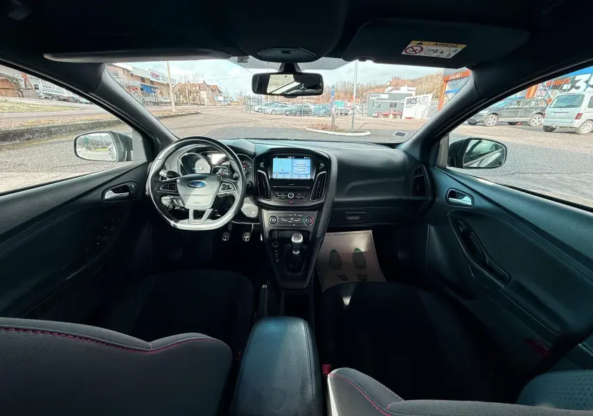 Gros plan sur la prise 12V et port USB près du levier de vitesses en cuir dans l’habitacle noir d’une Ford Focus gris 2018.