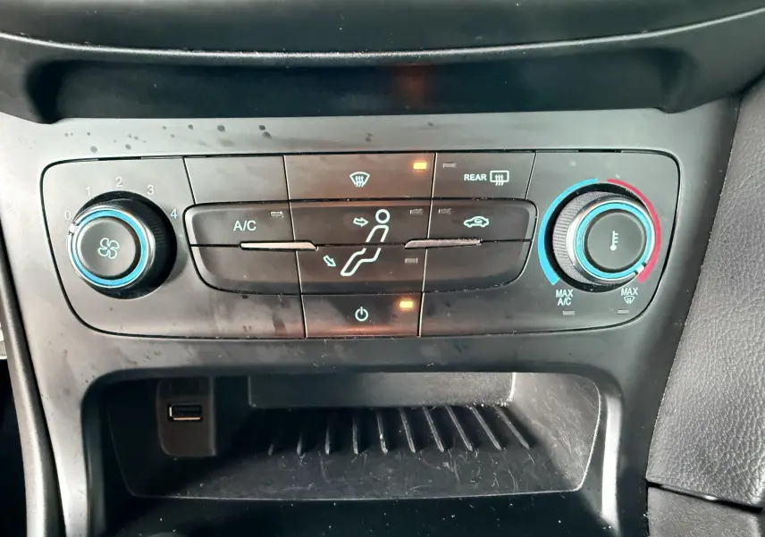 Gros plan sur les commandes de lève-vitres et réglage des rétroviseurs côté conducteur d'une Ford Focus gris 2018.