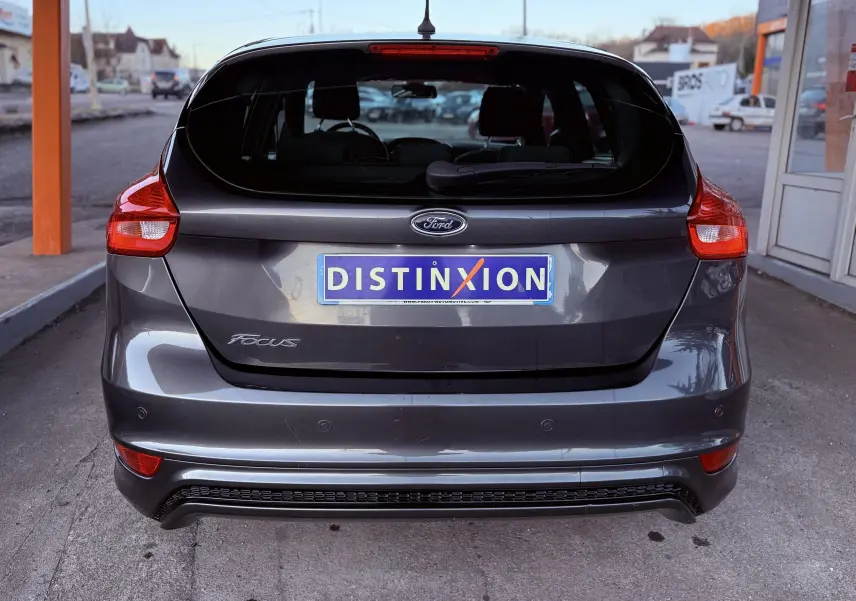 Vue arrière d’une Ford Focus gris métallisé 2018 avec hayon et feux rouges, immatriculée DISTINXION.