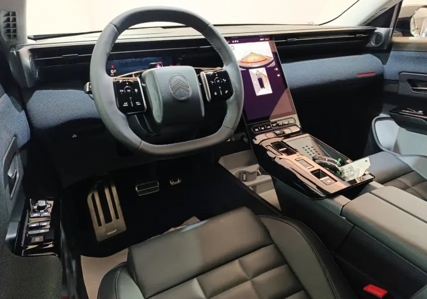 Intérieur de la Citroën C5 Hybride 2026, vue de face sur le volant cuir et l’écran tactile central vertical noir.