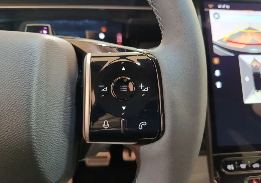Gros plan sur la commande multifonctions noire à droite du volant cuir gris du Citroën C5 Hybride 2026.