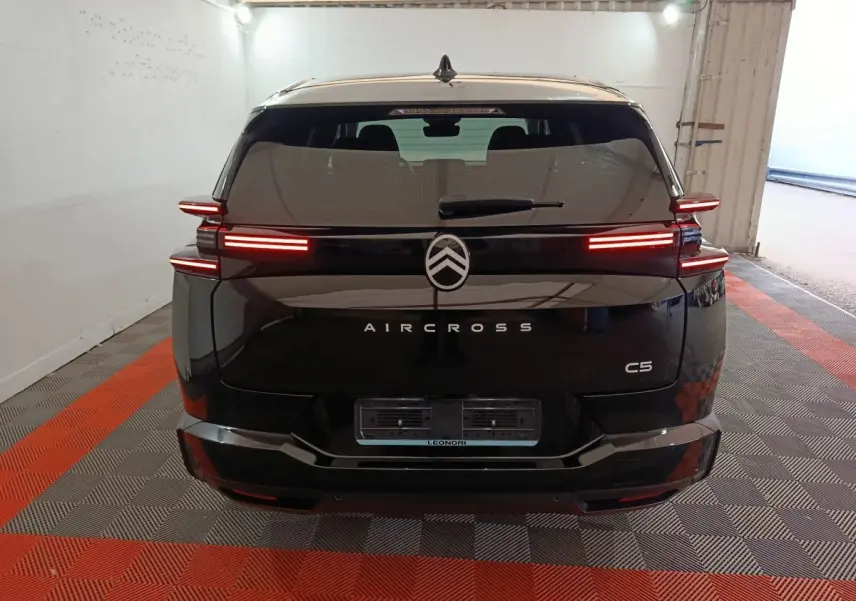 Vue arrière d'une Citroën C5 Aircross noire avec feux LED allumés dans un garage fermé.