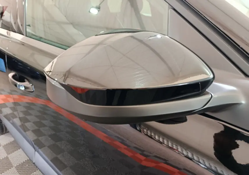 Rétroviseur côté gauche noir brillant de Citroën C5 Hybride 2026 avec carrosserie noire réfléchissante.