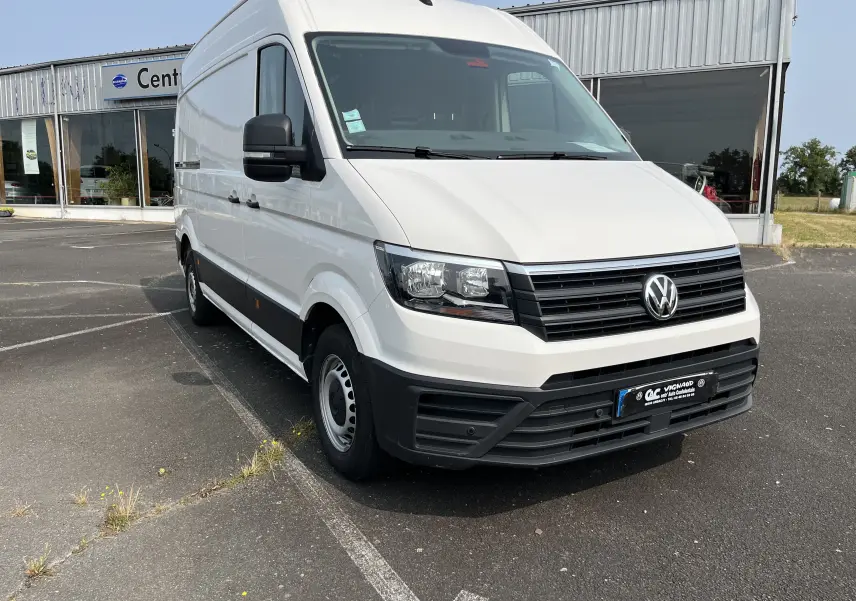 Vue 3/4 avant d’un Volkswagen Crafter blanc, fourgon utilitaire avec calandre noire et jantes acier simples.