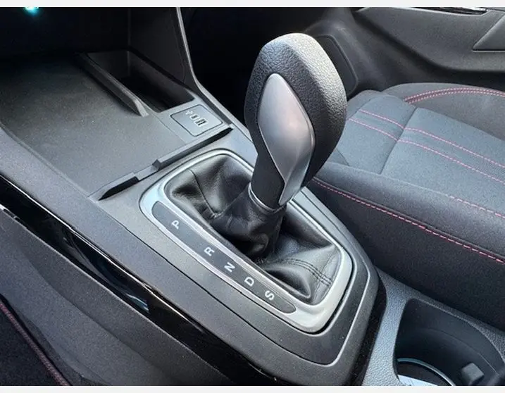 Le levier de vitesses automatique noir et gris du Ford Puma 2025 avec siège sport noir et surpiqûres rouges visible côté droit.