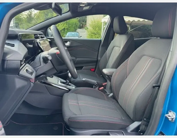 Vue intérieure côté conducteur du Ford Puma bleu Aqua Blue 2025, sièges sport noirs avec surpiqûres rouges ST LINE visibles.
