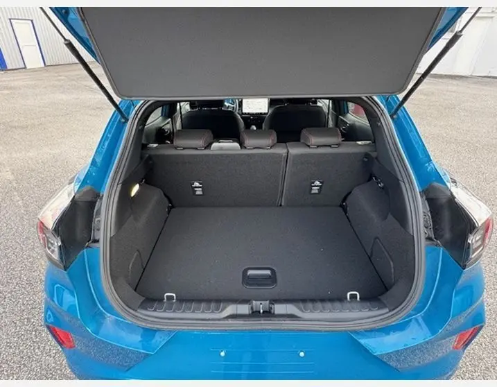 Coffre ouvert vu de l'arrière d'un Ford Puma bleu Aqua Blue 2025, montrant l'espace de chargement et les sièges arrière.