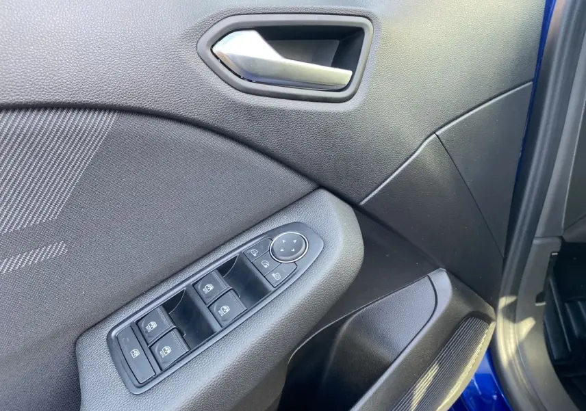 Intérieur de la porte avant gauche d'une Renault Clio V Bleu Iron, avec commandes électriques et poignée argentée.
