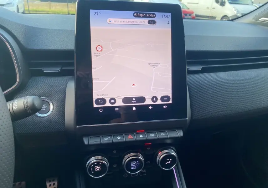 Tableau de bord de Renault Clio V bleu Iron 2025 avec écran tactile central affichant la navigation et commandes de climatisation.
