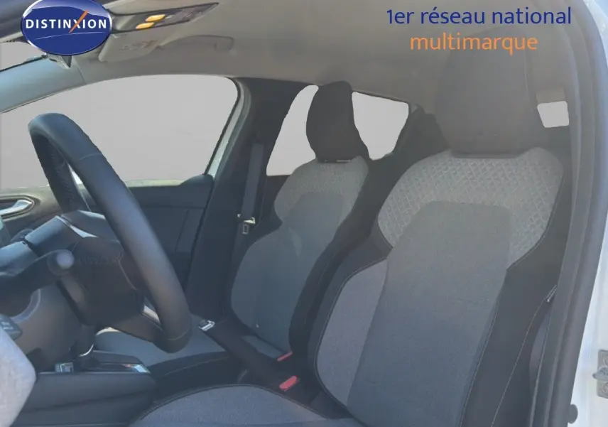 Vue intérieure côté conducteur de la Renault Clio blanche 2025, sièges tissu gris avec détails noirs et volant cuir multifonction.