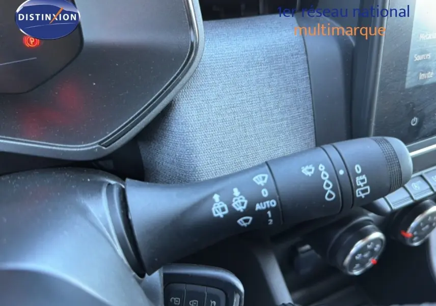 Gros plan sur la commande d’essuie-glace à gauche du volant dans l’habitacle d’une Renault Clio blanche 2025.