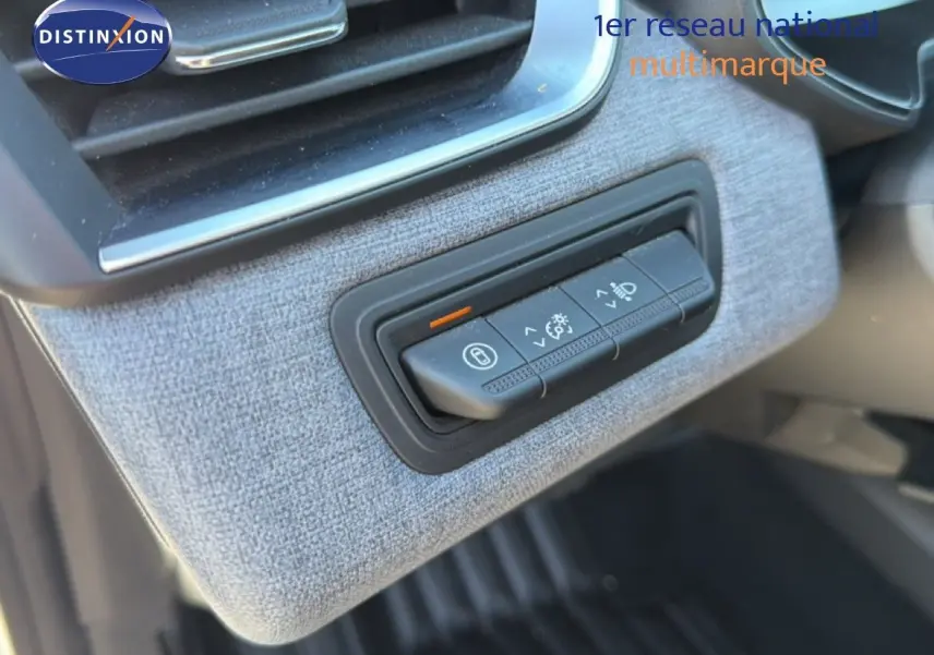 Détail des commandes d'éclairage sur tableau de bord avec finition tissu gris dans Renault Clio blanche 2025.