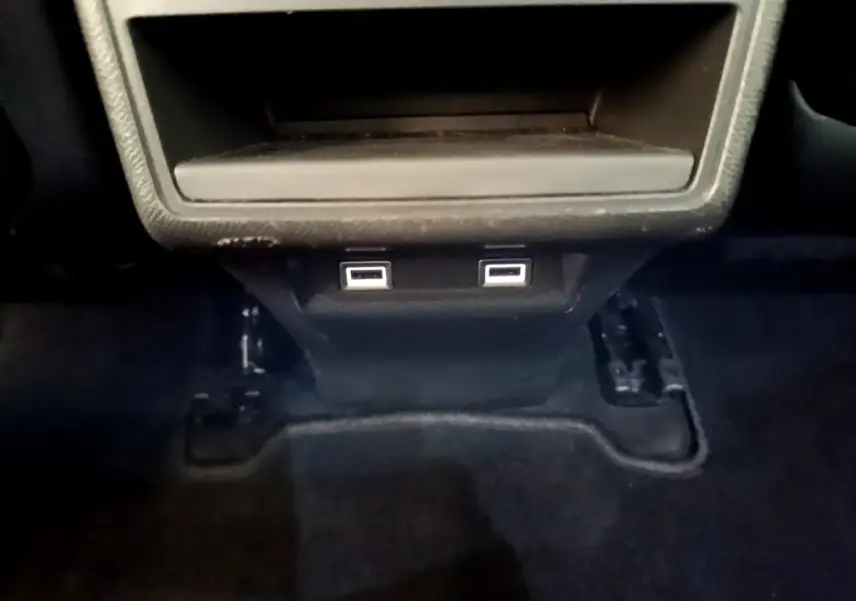 Gros plan sur les ports USB arrière noirs du DS7 Crossback gris foncé, sous la console centrale.