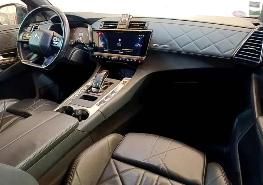 Vue intérieure côté passager du tableau de bord et console centrale en cuir noir matelassé du DS7 Crossback 2019.