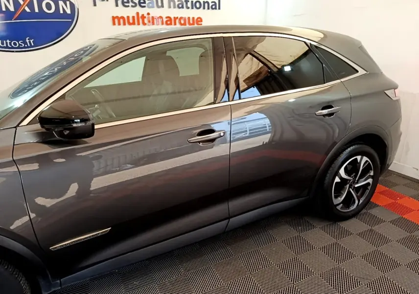 Vue de profil côté gauche du DS7 Crossback gris foncé avec jantes alliage et vitres teintées.