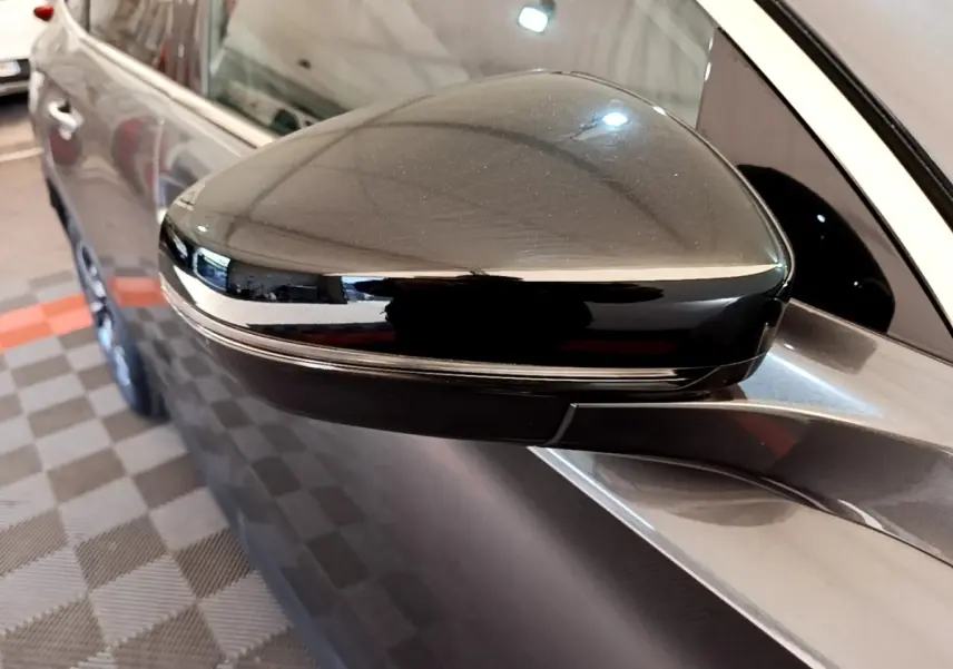 Rétroviseur droit noir brillant d'un DS7 Crossback gris foncé, vue rapprochée sur la porte avant côté droit.