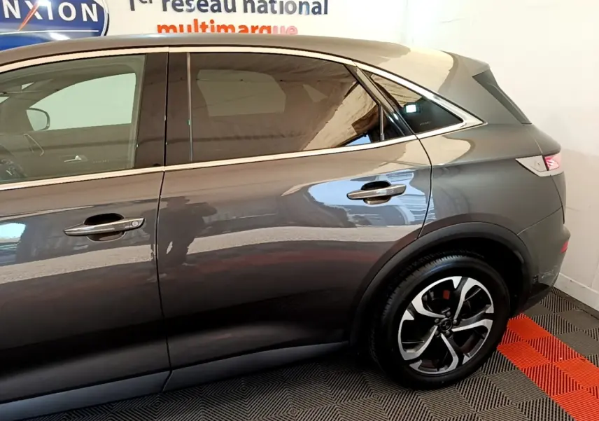 Vue latérale droite du DS7 Crossback gris foncé, mettant en valeur les jantes et la ligne de toit élégante.