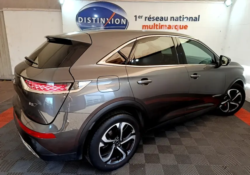 DS7 Crossback gris foncé vu en 3/4 arrière droit, avec feux arrière LED et jantes alliage distinctives.