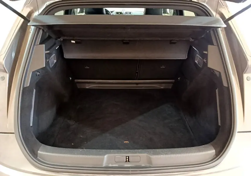 Coffre ouvert vu de l'arrière d'un DS7 Crossback gris foncé, montrant un espace de chargement vide et propre.