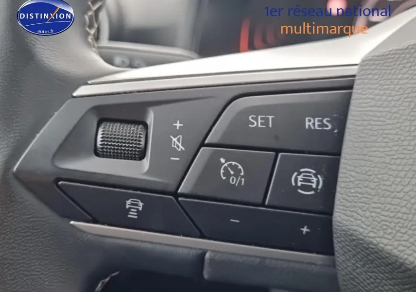 Gros plan sur les commandes du volant cuir multifonction du SEAT Arona gris magnétique, boutons de régulateur de vitesse.