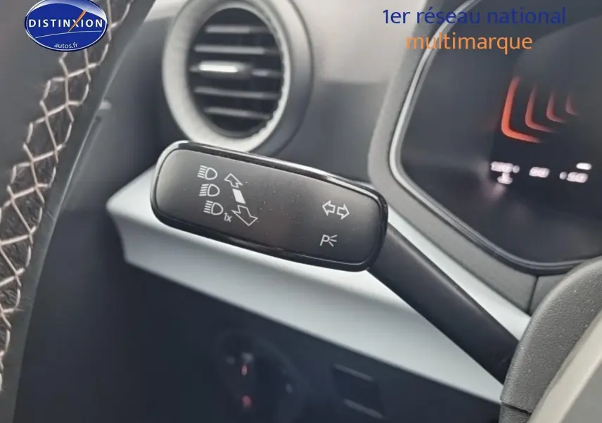 Gros plan sur la manette de clignotant et feux du tableau de bord d’un SEAT Arona gris magnétique 2025.