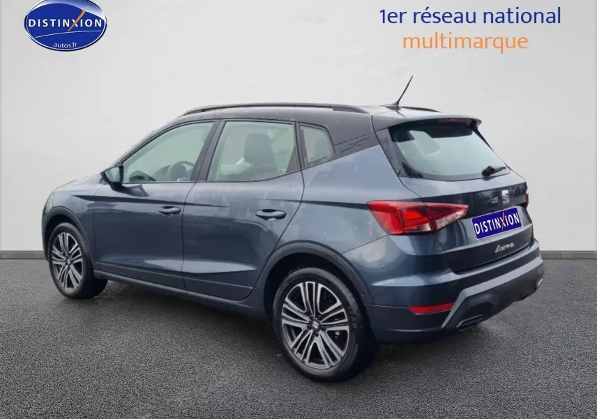 SEAT Arona gris magnétique vu en 3/4 arrière droit, avec jantes 17 pouces et toit noir contrasté.