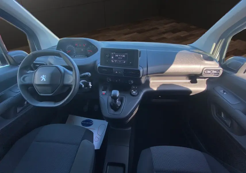 Vue intérieure avant du Peugeot Partner Fourgon Dangel 4x4 2025, tableau de bord et sièges tissu noir visibles.