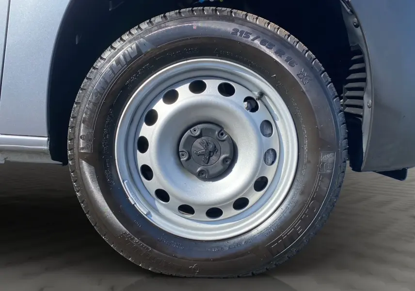 Gros plan sur la roue avant droite en jante tôle grise du Peugeot Partner Fourgon Dangel 4x4 gris Artense.