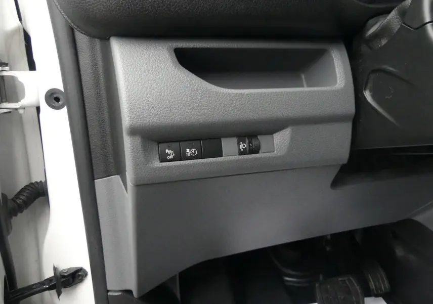 Détail des commandes sous le tableau de bord côté gauche du Peugeot Expert Fourgon blanc 2019.