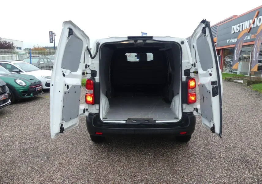 Vue arrière du Peugeot Expert Fourgon blanc 2019 avec portes arrière ouvertes et espace de chargement vide visible.