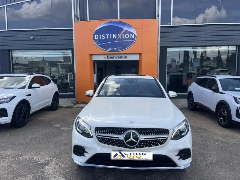 Vue frontale d'un Mercedes GLC Coupé blanc diamant brillant designo garé devant un concessionnaire Distinxion.