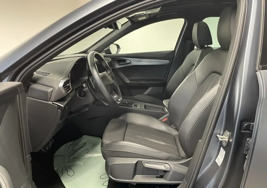 Intérieur du CUPRA Formentor 1.5 TSI 2023 vu côté conducteur, sièges cuir gris et tableau de bord moderne.