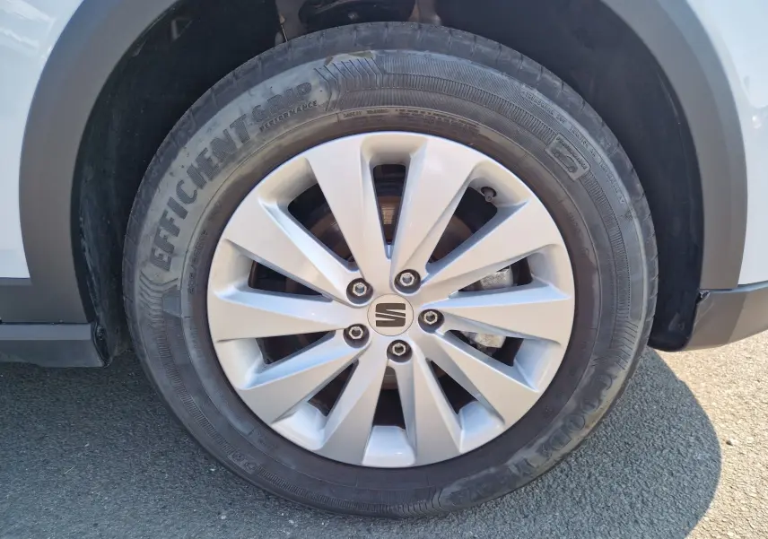 Gros plan sur la roue avant gauche du SEAT Arona blanc alpin métal avec jante alliage et pneu Goodyear.