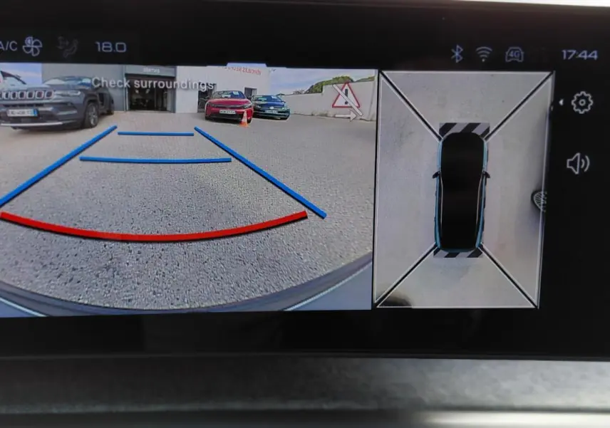 Vue écran multimédia du Peugeot 3008 Hybrid noir 2025 montrant la caméra de recul et la vue 360° du véhicule en stationnement.